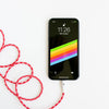 A smartphone is displayed with a screen that shows the time as 11:26 and a battery level of 96% charged. The phone's background features a colorful diagonal stripe design. A ChargeCords Candy Cane Lightning Cable [5 ft / 1.5m length], coiled in red, is connected to the phone, set against a white background.